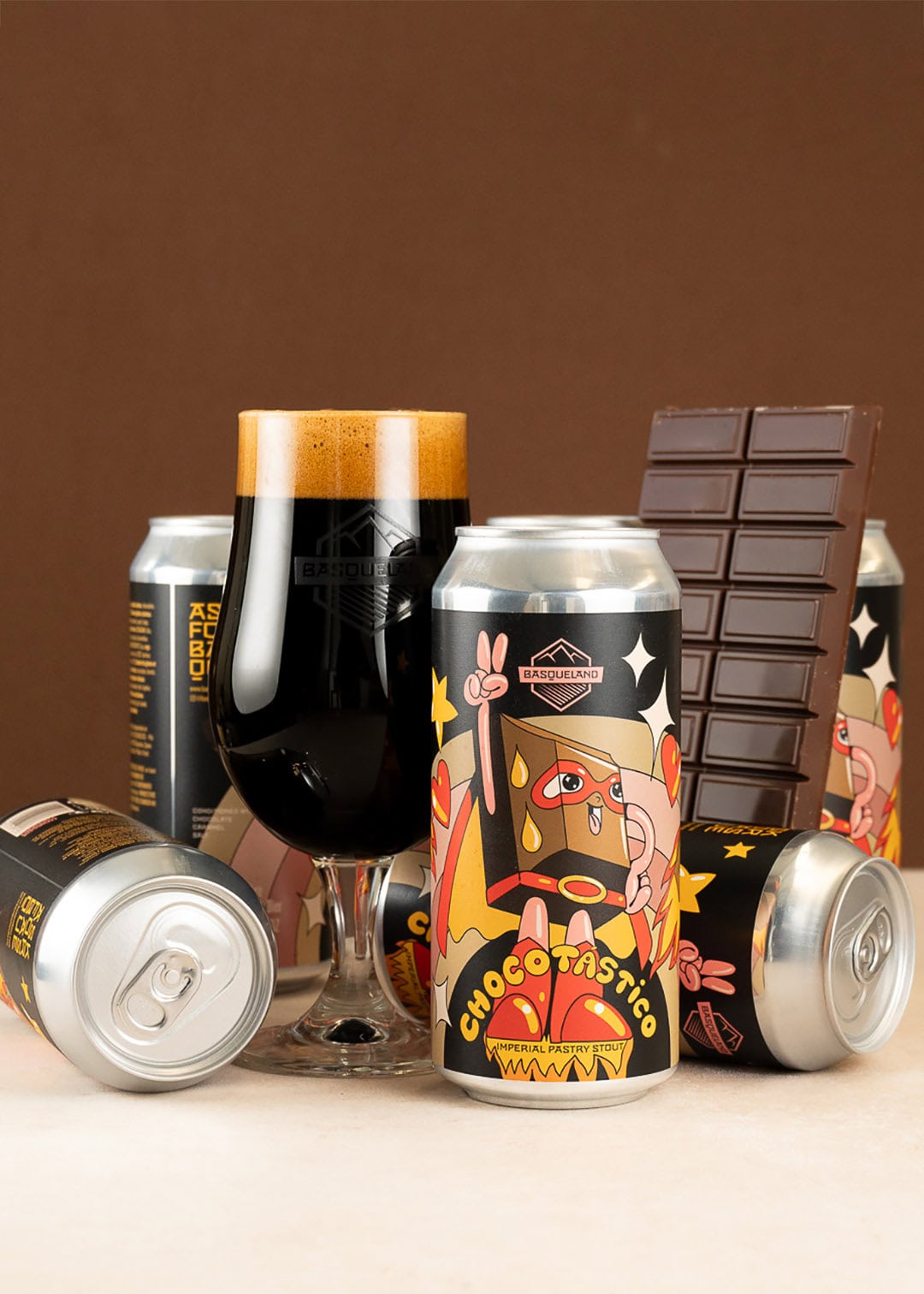 Chocotástico cerveza basqueland bodegon con copa cerveza negra y latas de diseño